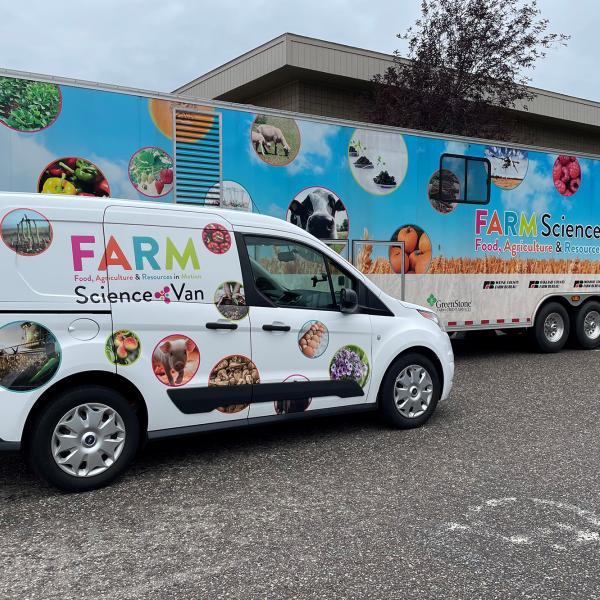 Wide profile shot of the FARM Science Lab and the FARM Science Van parked side-by-side in a parking lot.