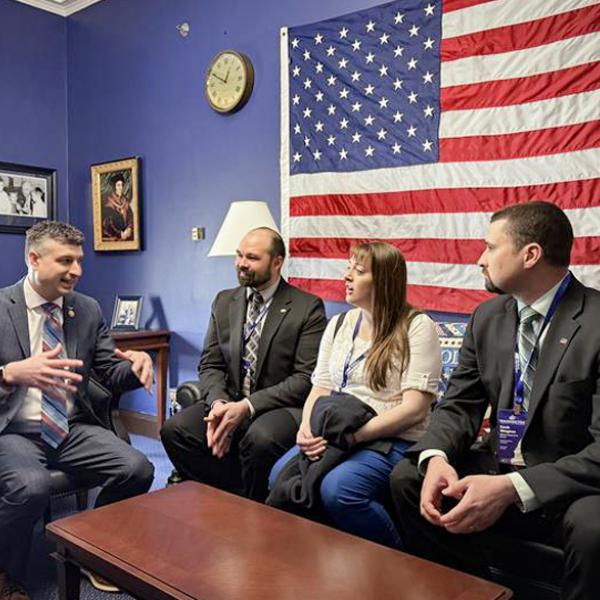 Three Michigan Farm Bureau members speaking with Sen. Tom Barrett in his office at the 2025 Washington Legislative Seminar.