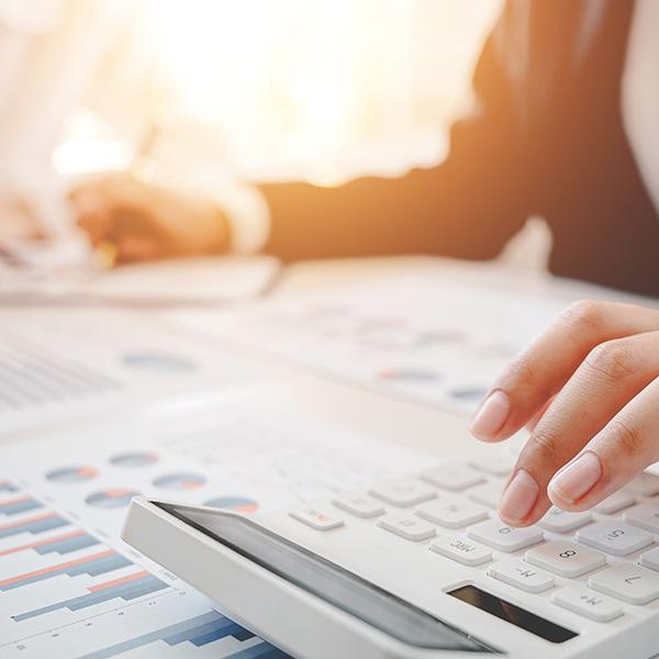 Woman using a calculator to prepare taxes documents for her client.